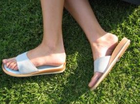 Füße in Sandalen auf einer Wiese